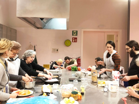 Joves i gent gran cuinant a la Cuina Comunitària de Sant Antoni